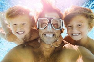 мъж с две деца се гмуркат под вода