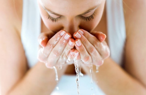 жена мие лицето си с вода